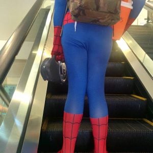 a person wearing a spiderman costume riding an escalator
