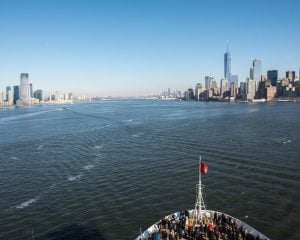 a cunard line cruiseship passes through the hudson river new york city