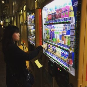 a tourist selects a drink from a vending machine tokyo
