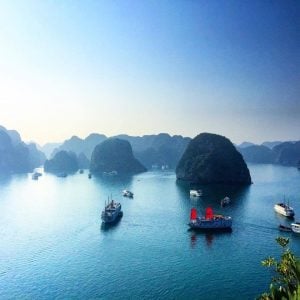 boats navigate through mountainous islands in vietnam
