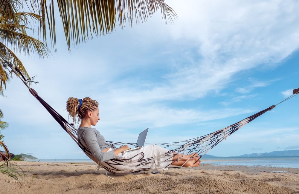 Woman relaxing and working on a hammock