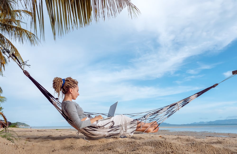 Woman relaxing and working on a hammock