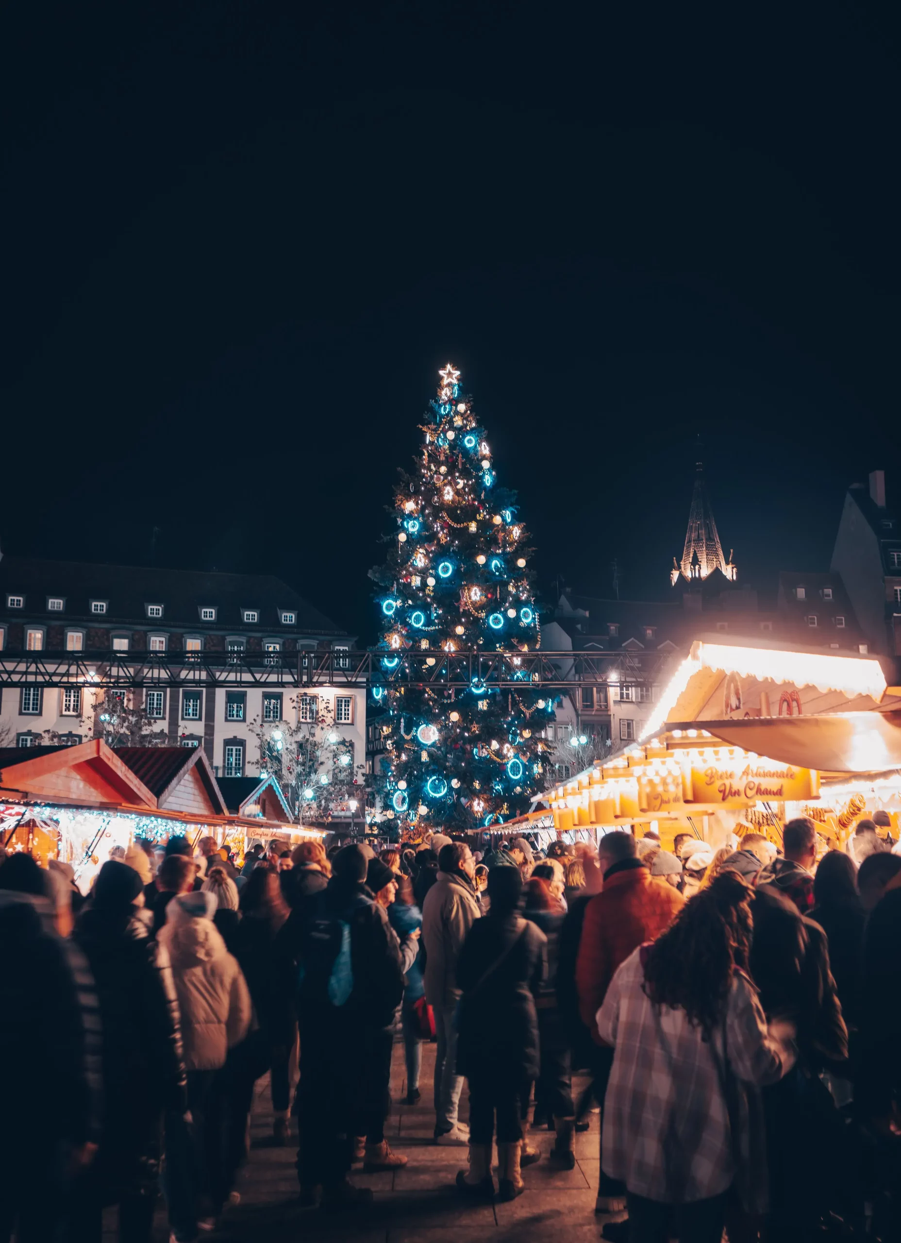 A large Christmas tree and market stalls at the Christkindelsmärik in Strasbourg, France
