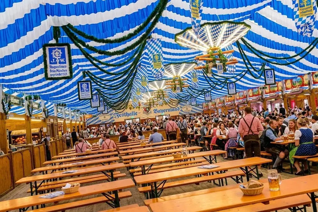Traditional Bavarian tent at Oktoberfest in daytime with growing crowds